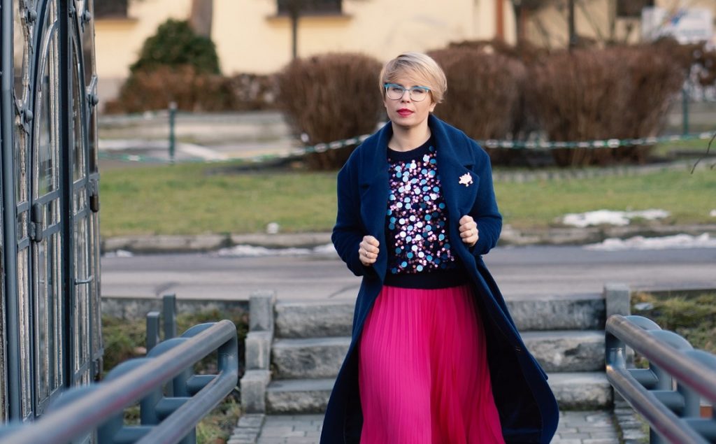 młoda kobieta idąca po schodach przezentuje swoją kolorową stylizację zimową